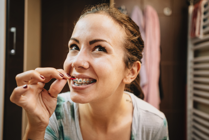 Kobieta myjąca zęby szczoteczką międzyzębową